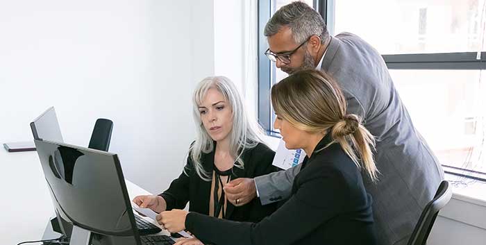 Business team of three analyzing reports stock photo