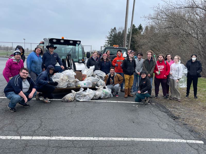 Group of people with filled garbage bags of refuse removed from campus in celebration of Earth Week