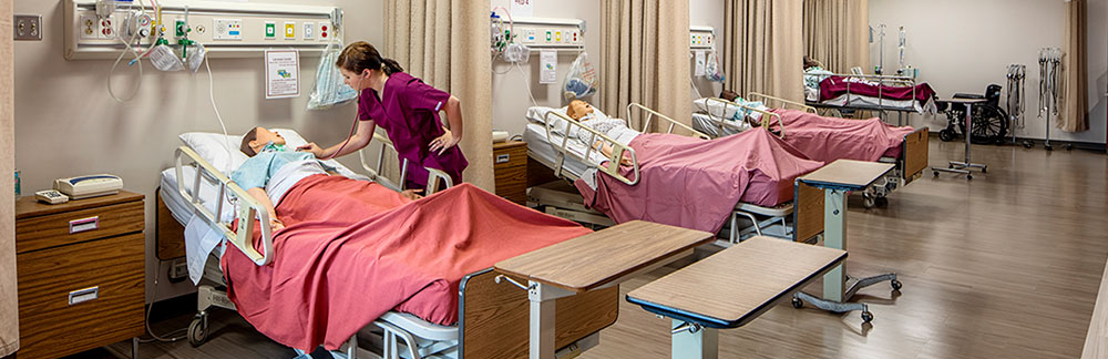 Student attending to nursing manikin