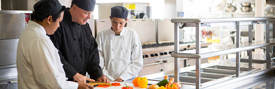 Professor and two students working in kitchen