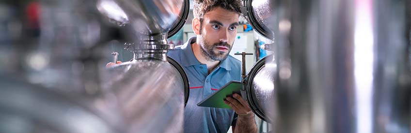 Person examining wine vats