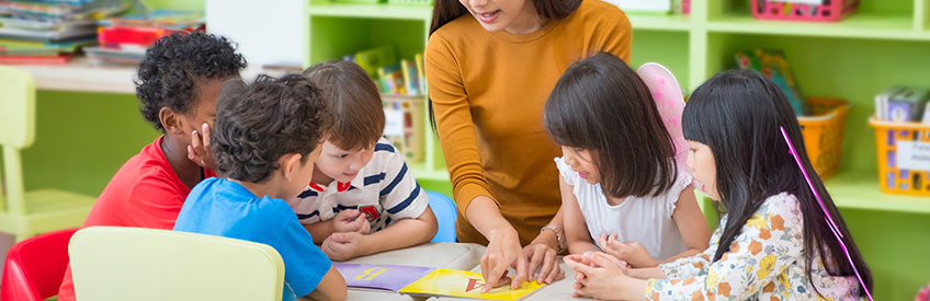 Early childhood teacher working with group of kids