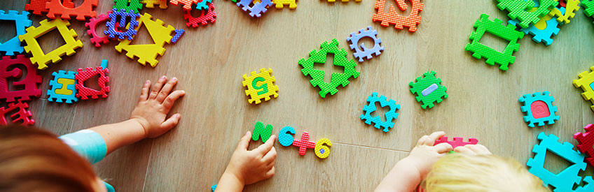 Teacher and infant with learning blocks