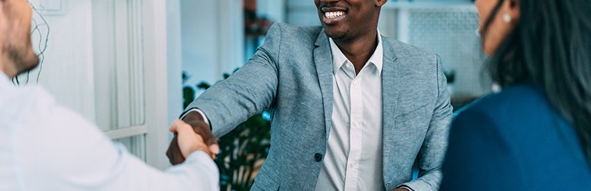 Human resources administrator shaking hands while onboarding new employee