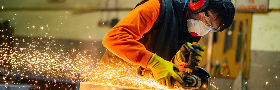 Worker metal processing with angle grinder.