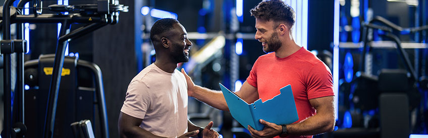 Fitness instructor and his client communicating in the gym.