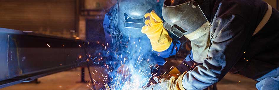 Two welders working together on fabrication