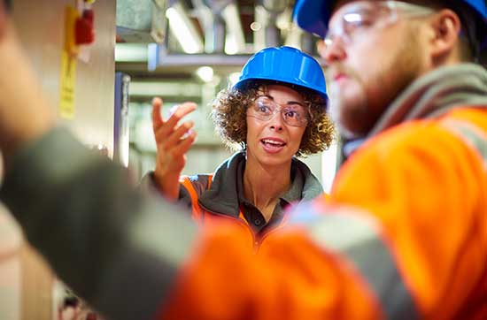 Female and Male with hard hats on worksite