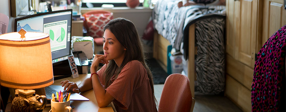 student sitting in living room in east hall suite