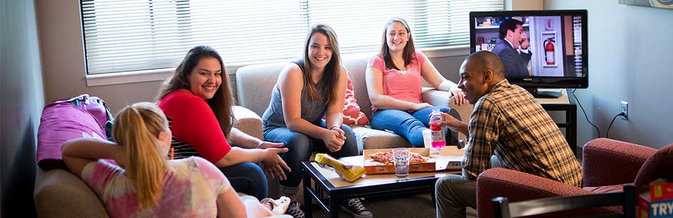 students sitting in living room in east hall suite